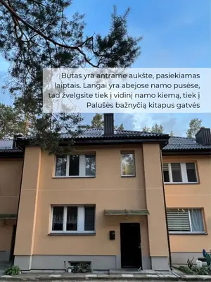 a building with a sign on the side of it at Palūšės Apartment in Palūšė