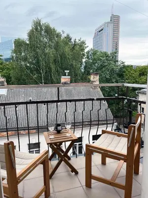 a patio with two tables and chairs on a roof at NERIS Apartments in Vilnius