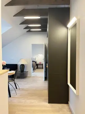 an office corridor with a black wall and a table and chairs at NERIS Apartments in Vilnius