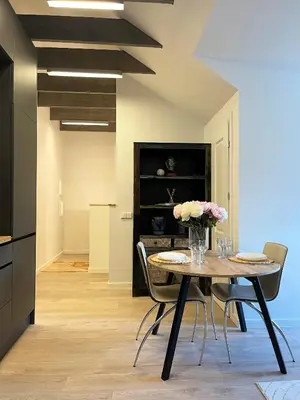 a dining room with a table with flowers on it at NERIS Apartments in Vilnius