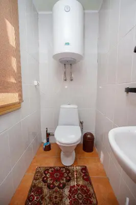a bathroom with a white toilet and a sink at Meškiai in Meškiai