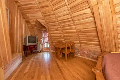 a room with a table and a tv in a cabin at Meškiai in Meškiai