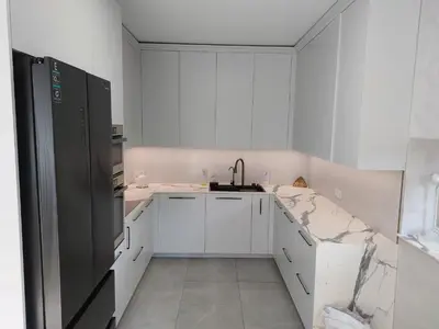 a white kitchen with white cabinets and a sink at Big Mama Koala in Druskininkai