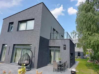 a black and white house with a table and chairs at Big Mama Koala in Druskininkai