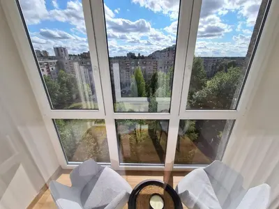 a room with two chairs and a large window at Samanų apartamentai in Šiauliai