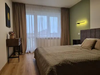 a bedroom with a bed and a large window at Samanų apartamentai in Šiauliai