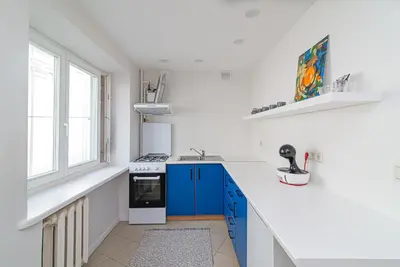 a white kitchen with blue cabinets and a sink at Slow-down, relax, take it easy in artsy Oasy in Vilnius