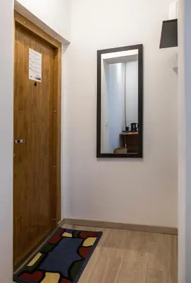 a mirror on a wall next to a door at Mini Studio Vilnius Centre in Vilnius