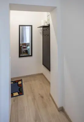 a living room with a mirror and a table at Mini Studio Vilnius Centre in Vilnius