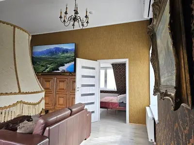 a living room with a couch and a painting on the wall at Square apartments in Rokiškis