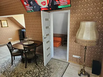 a dining room with a table and a lamp at Square apartments in Rokiškis
