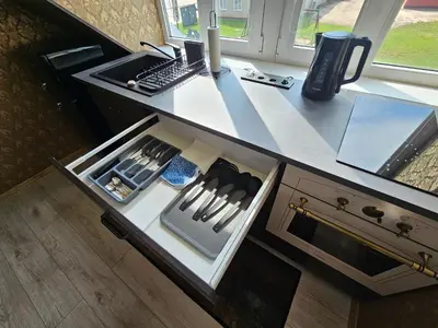 a kitchen counter with an open drawer with knives at Square apartments in Rokiškis