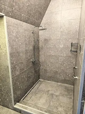 a shower with a glass door in a bathroom at Square apartments in Rokiškis