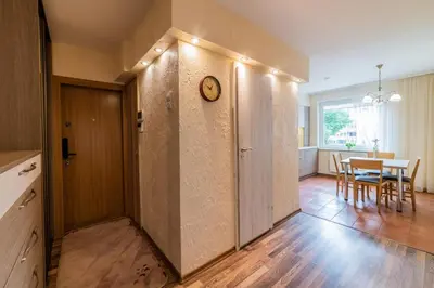 a hallway with a clock on a wall with a table at A.P. Apartment in Šiauliai
