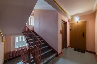 an empty hallway with stairs and a door at A.P. Apartment in Šiauliai
