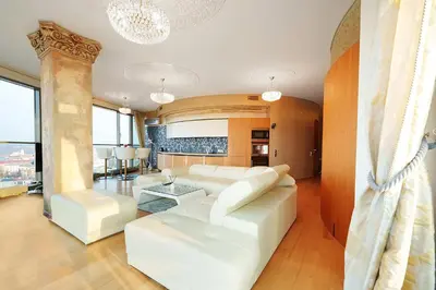a living room with white furniture and large windows at Helios Extra Apartment in Vilnius skyscraper 20 floor in Vilnius