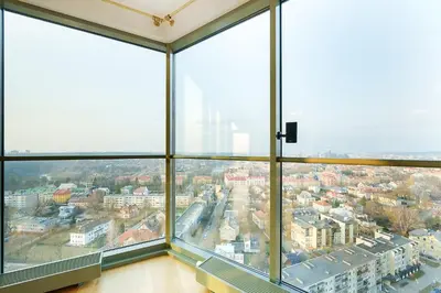 a view of a city from a large window at Helios Extra Apartment in Vilnius skyscraper 20 floor in Vilnius