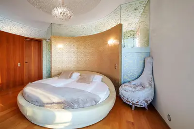 a bedroom with a large bed and a chair at Helios Extra Apartment in Vilnius skyscraper 20 floor in Vilnius