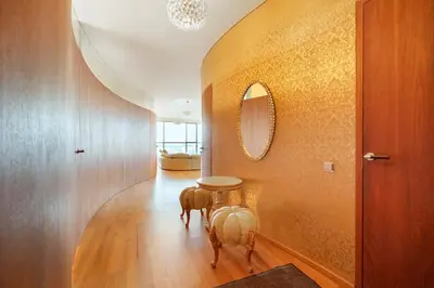a hallway with a table and a mirror on a wall at Helios Extra Apartment in Vilnius skyscraper 20 floor in Vilnius
