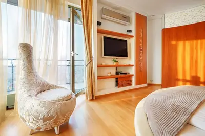 a living room with a chair and a television at Helios Extra Apartment in Vilnius skyscraper 20 floor in Vilnius