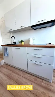 a kitchen with white cabinets and a wooden counter top at Mano erdvės in Anykščiai