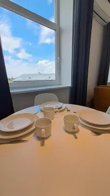 a table with plates and cups on it with a window at Mano erdvės in Anykščiai