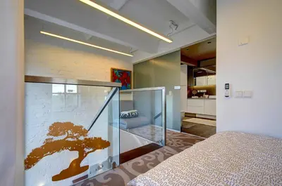 a bedroom with a glass wall with a tree mural at Loft 66/A nice view Vilnius in Vilnius
