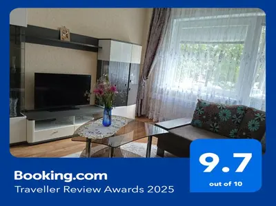 a living room with a tv and a vase of flowers on a table at Welcome home Taikos 72V-22 in Visaginas