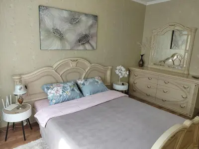 a bedroom with a large bed and a dresser at Welcome home Taikos 72V-22 in Visaginas