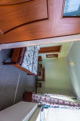 a small room with a bunk bed and wooden cabinets at Regina House in Kaunas