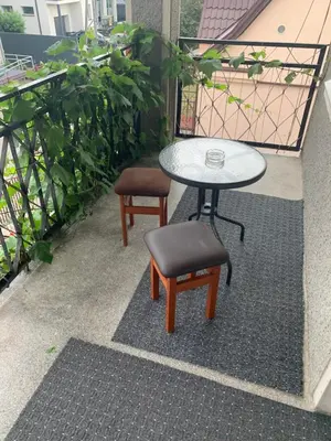 a table and a stool and a table on a balcony at Regina House in Kaunas