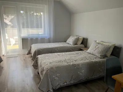 a bedroom with two beds and a window at Naisiai-2 in Naisiai