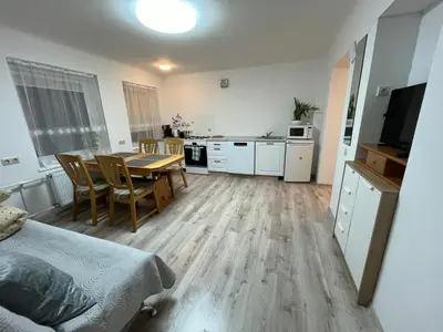 a kitchen and dining room with a table in a room at Naisiai in Naisiai