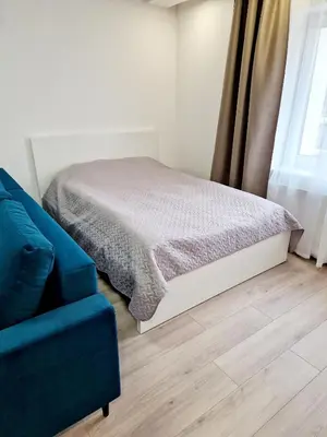 a bedroom with a bed and a blue couch at Apartments in Lazdijai in Lazdijai