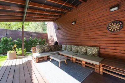 a patio with a bench and a wooden wall at Cozy apartments by the river near old town in Kaunas