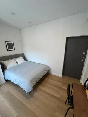a bedroom with a bed and a desk and a television at 11A Airport Apartment in Vilnius