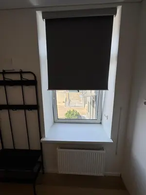 a window with a black blind in a room at 11A Airport Apartment in Vilnius