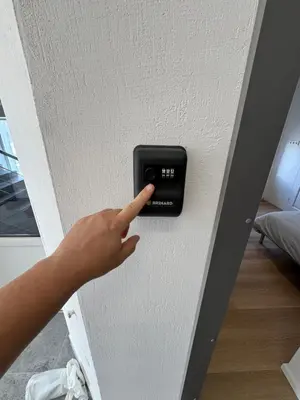 a hand pointing at a button on a wall at 11A Airport Apartment in Vilnius