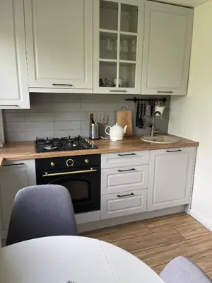 a kitchen with white cabinets and a stove at Arena apartment in Panevėžys