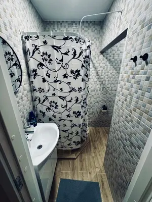 a bathroom with a black and white shower curtain and a sink at AJ Chocolate Vilnius in Vilnius