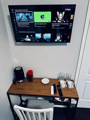 a wooden table with a tv hanging on a wall at AJ Chocolate Vilnius in Vilnius