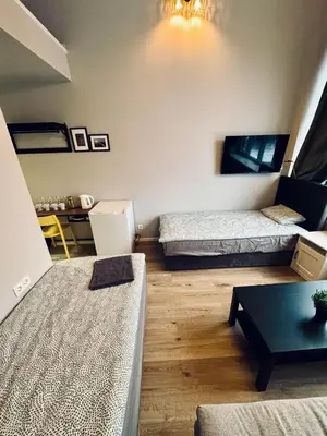 a living room with two beds and a table at AJ Chocolate Vilnius in Vilnius