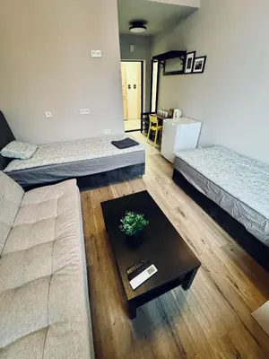 a living room with two beds and a coffee table at AJ Chocolate Vilnius in Vilnius