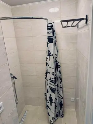 a bathroom with a shower with a black and white shower curtain at AJ Chocolate Vilnius in Vilnius