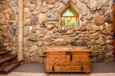 a stone wall with a window and a trunk at Neries Vila in Liucionys