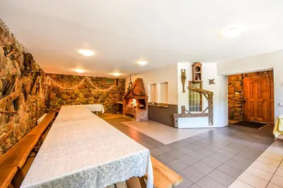 a room with a table and a stone wall at Neries Vila in Liucionys