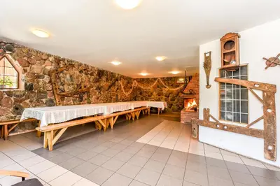 a room with a stone wall with benches in it at Neries Vila in Liucionys