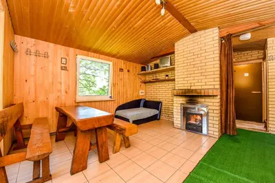 a living room with a table and a fireplace at Neries Vila in Liucionys
