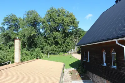 a house with a black roof and a yard at Neries Vila in Liucionys