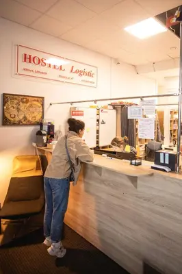 a woman standing at the counter of ahotel lexicangering at Capsule Hostel Logistic Vilnius in Vilnius